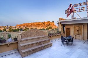 a balcony with stairs and a table and chairs at Hotel Sky Plaza - Best ever view of Jaisalmer Fort in Jaisalmer