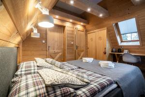 a bedroom with a bed in a wooden cabin at Willa Mountain Centrum in Zakopane