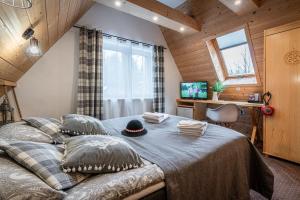 a bedroom with a bed with a hat on it at Willa Mountain Centrum in Zakopane