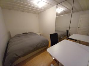a small room with a bed and a table at Private Room with No Windows in Shared House-4 in Umeå