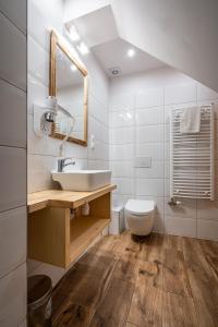a white bathroom with a sink and a toilet at Willa Mountain Centrum in Zakopane