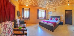 a bedroom with a bed and a couch in a room at Hotel Sky Plaza - Best ever view of Jaisalmer Fort in Jaisalmer