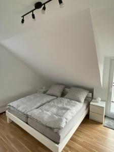 a white bedroom with a bed in a white wall at Ferienwohnung mit Aussicht in Koblenz