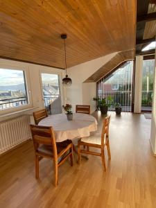 a dining room with a table and chairs and windows at Ferienwohnung mit Aussicht in Koblenz