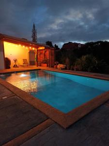a swimming pool in a backyard at night at Chambres d'hôte Sud Basse-Terre in Gourbeyre