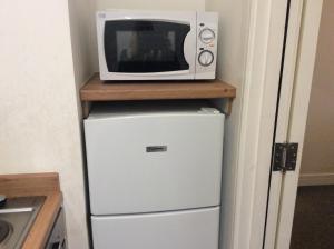 a microwave sitting on top of a refrigerator at 103 Nelson Street Ground Right Largs in Largs