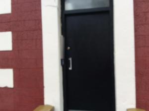 a black door on the side of a building at 103 Nelson Street Ground Right Largs in Largs