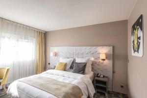 um quarto com uma cama grande e uma janela em Mercure Annecy Sud em Annecy