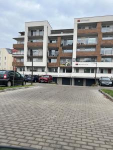 ein Parkplatz vor einem großen Gebäude in der Unterkunft Apartament Parys Gold in Malbork