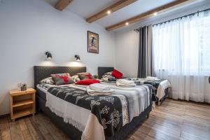 a bedroom with two beds and a window at Willa Mountain Centrum in Zakopane