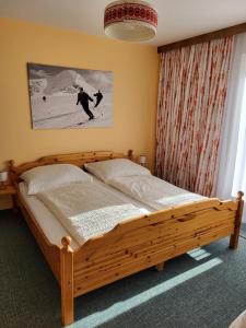 ピーゼンドルフにあるLandhaus Flatscherのベッドルーム1室(木製ベッド1台付)