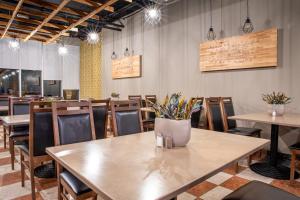 a restaurant with tables and chairs and a vase of flowers at Rija Bauska Hotel in Bauska