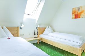 duas camas num quarto com lençóis brancos em Ferienhaus Kleine Gartenvilla em Pörtschach am Wörthersee