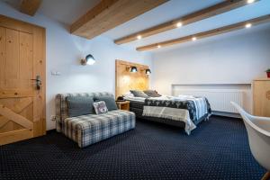 a bathroom with two beds and a chair and a tub at Willa Mountain Centrum in Zakopane