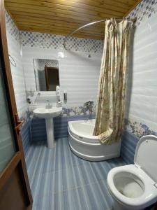 Un baño con bañera, inodoro y lavabo. en UHUM GUESTHOUSE nuratau mountain, en Kyzylkumskiy