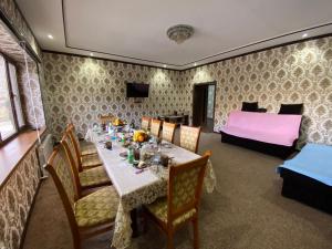 comedor con mesa y cama en UHUM GUESTHOUSE nuratau mountain, en Kyzylkumskiy