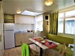 una piccola cucina con tavolo e frigorifero di Pleasant holiday home in Cupra Marittima with garden a Cupra Marittima