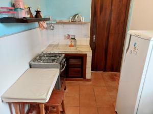 una piccola cucina con fornelli e frigorifero di Casa a 130 metros da praia de Boiçucanga a São Sebastião