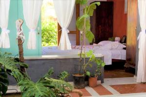 een slaapkamer met een bed en een spiegel en planten bij Villa Rodialos in Panormos Rethymno