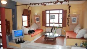 een woonkamer met 2 banken en een televisie bij Villa Rodialos in Panormos Rethymno