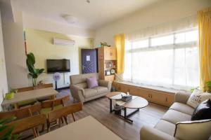 ein Wohnzimmer mit einem Sofa und einem Tisch in der Unterkunft 紅築民宿 in Jincheng