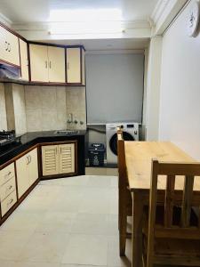 a large kitchen with a table and a stove at Newa service apartment in Pātan