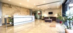 a lobby with a couch and a tv in a building at Hotel Marine House in Agra