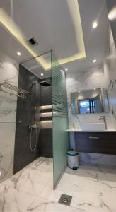 a bathroom with a shower and a sink and a mirror at ريفان لبيوت الضيافة خاصة in Yanbu