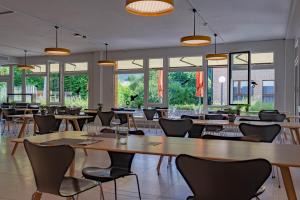 un restaurante con mesas, sillas y ventanas en The Lab Experiments en Thun