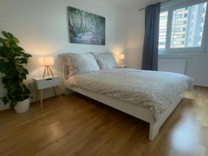 a bedroom with a bed with two lamps and a plant at 55 m2 Stylish Apartment with Balcony and Netflix in Vienna