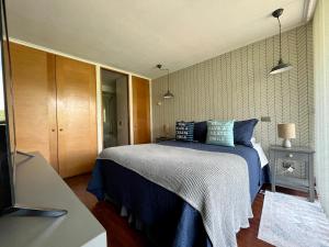a bedroom with a bed with a blue blanket at Apartamentos City Centro Los Leones in Santiago