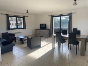 a living room with a table and chairs at Appartement tout confort au milieu de la Margeride in Châteauneuf-de-Randon
