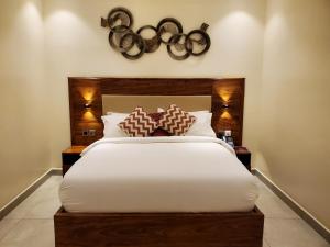 a bedroom with a large white bed with brown pillows at Millennium Terrace Hotel in Kampala