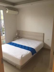 una camera da letto con un letto con un nastro blu sopra di Chaweng Beach Apartment 1 Schlafzi-1Wohnzi-Pool-Fitnes a Ban Ko Khwan
