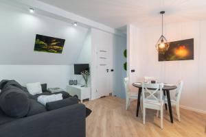 a living room with a couch and a table at Apartament Z widokiem na las in Witów