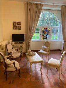 un soggiorno con sedie, TV e finestra di Manoir de Saint-Fiacre a Malansac