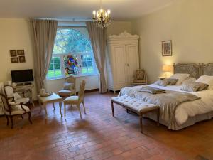 a bedroom with a large bed and a chandelier at Manoir de Saint-Fiacre in Malansac