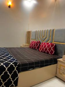 - un lit avec 2 oreillers rouges dans l'établissement Gulshan Guest House Karachi, à Karachi