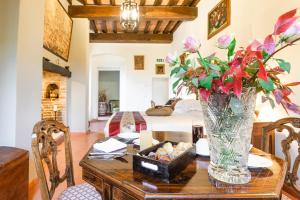 a dining room table with a vase of flowers on it at Borgo Petroro in Todi