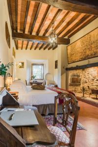 - une chambre avec un lit et un mur en pierre dans l'établissement Borgo Petroro, à Todi