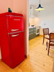 a red refrigerator in a kitchen with a table at Kuschelige helle Ferienwohnung in Gotha