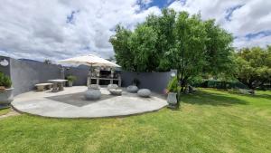 Adendorp的住宿－KarooSjiek Self-catering，庭院里设有带桌子和遮阳伞的庭院。