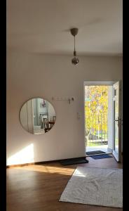 ein Wohnzimmer mit einem Spiegel und einer Tür in der Unterkunft Appartamento Ticino in Monte Carasso