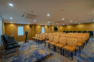 a conference room with a row of chairs and a podium at THE PORT BY JDANIELS in Trivandrum
