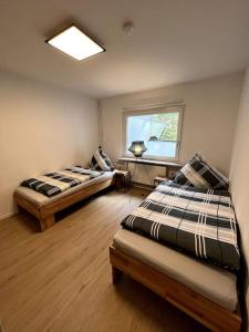 two beds sitting in a room with a window at Ferienwohnung am Hang mit malerischer Aussicht in Osterode