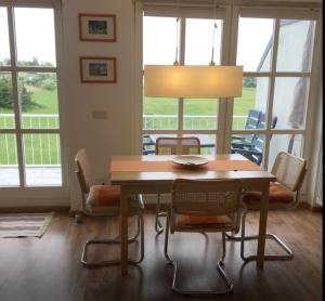 a dining room table with chairs and a lamp at Ferienwohnung Boddenblick in Zudar