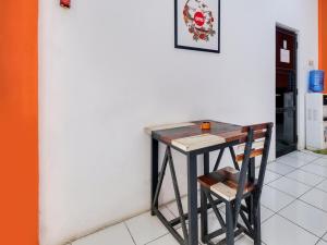 een kleine tafel en een stoel naast een muur bij SPOT ON 2451 Camel Residence in Semarang