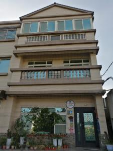 a tall building with a balcony on top of it at 紅築民宿 in Jincheng