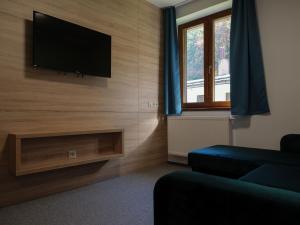 a living room with a flat screen tv on a wall at EKOREZORT VENDELIN 
