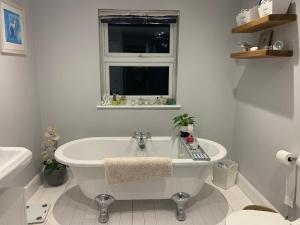 a white bathroom with a tub and a window at Best Location! Town & Racecourse! in Cheltenham